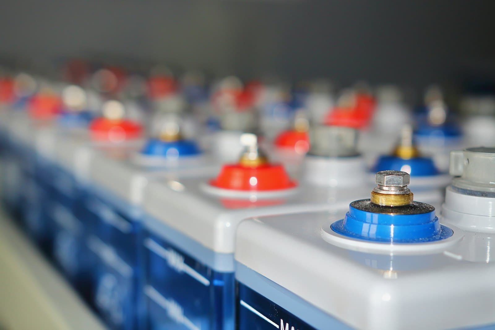 Rows of industrial battery cells with red and blue terminals