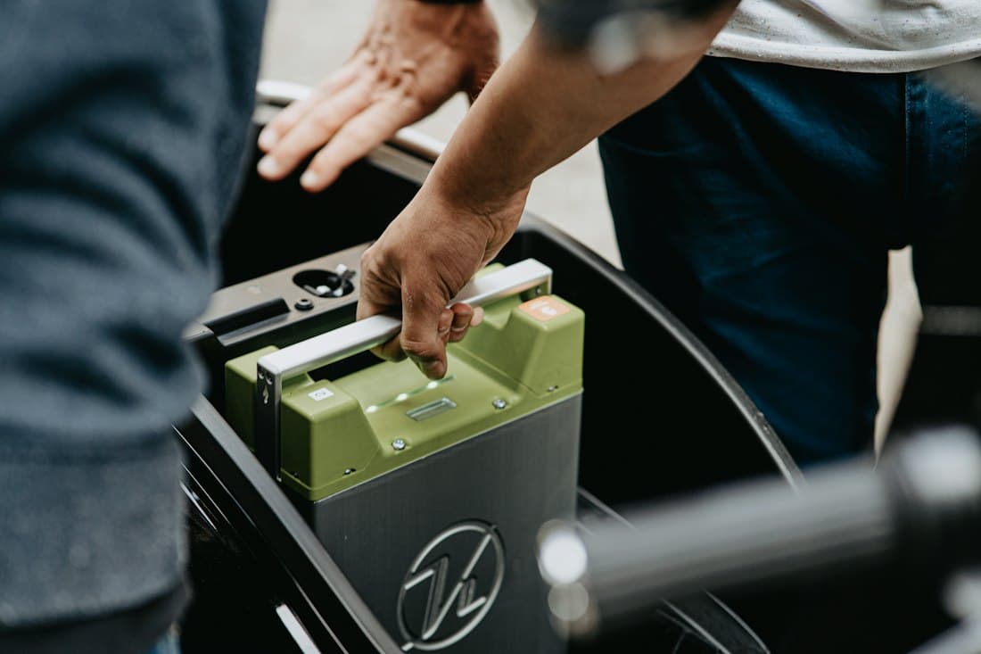Hands lifting a battery into place
